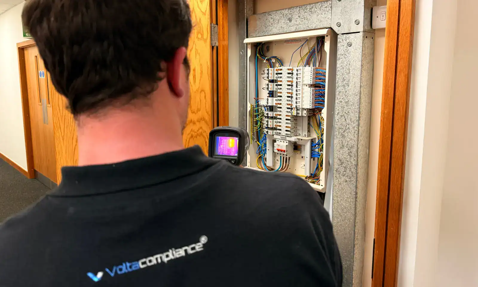 Volta Compliance engineer using a thermal camera on an open distribution board
